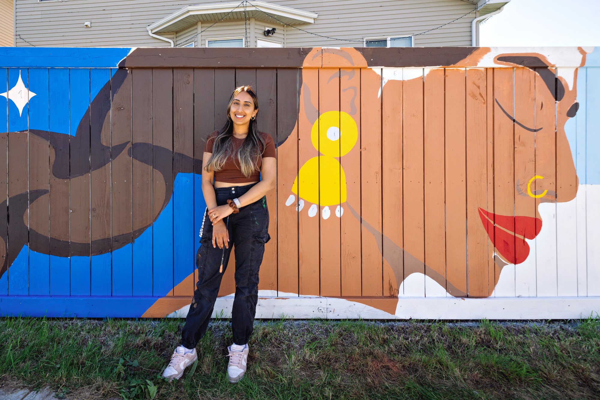 Kiran Rai-Bhullar standing in front of the mural